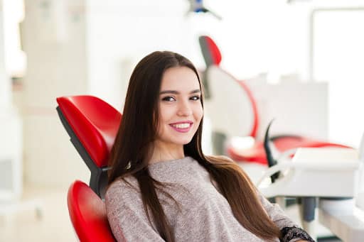 girl in red chair smiling